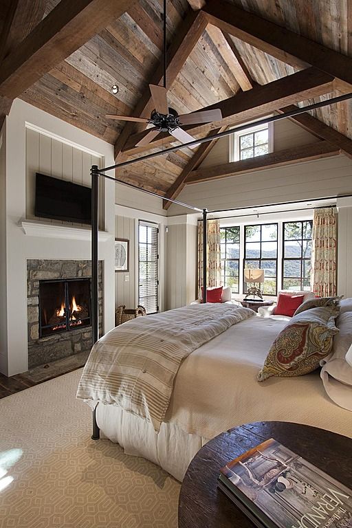 Спальня в деревенском стиле с каменным камином.