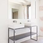 Индустриальная простота грубо свареной основы умывальника и большое зеркало в ванной отлично гармонируют с деревенским стилем дома.