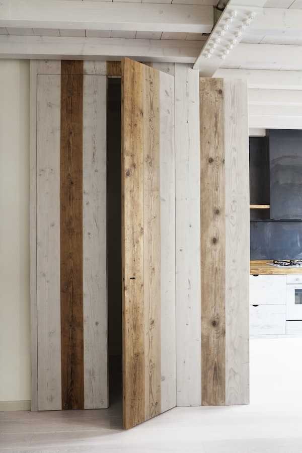 Дверь в шкаф из дерева разных оттенков подчеркивает натуральность материалов отделки кухни