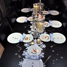 Сервировка стола с тарелочками в виде снеговиков.
