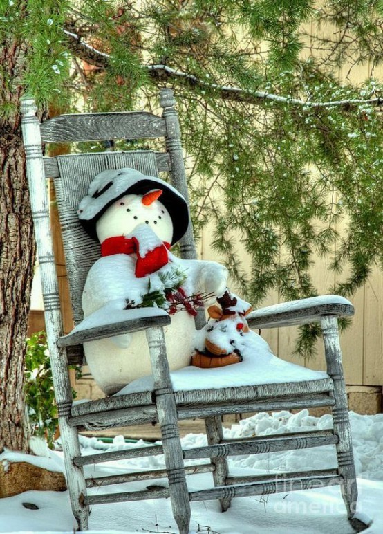 Снеговик в старом кресле-качалке перед домом.