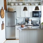 В маленькой кухне имеет смысл использовать не только горизонтальные поверхности, а и всю высоту кухни. Это могут быть и различные системы хранения, и висящая на стене микроволновка.