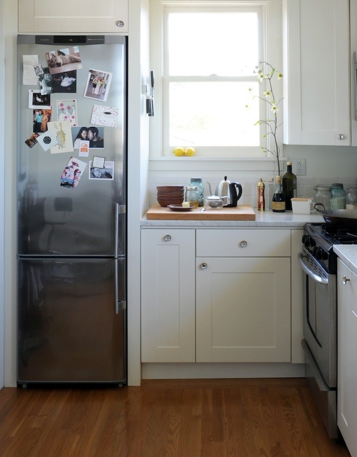 В маленькой кухне есть смысл поставить холодильник меньшего размера, а пространство над ним использовать для хранения кухонных принадлежностей или для микроволновой печки