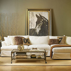 Большая картина лошади стоящая на полу за диваном в эклектичном интерьере квартиры.
