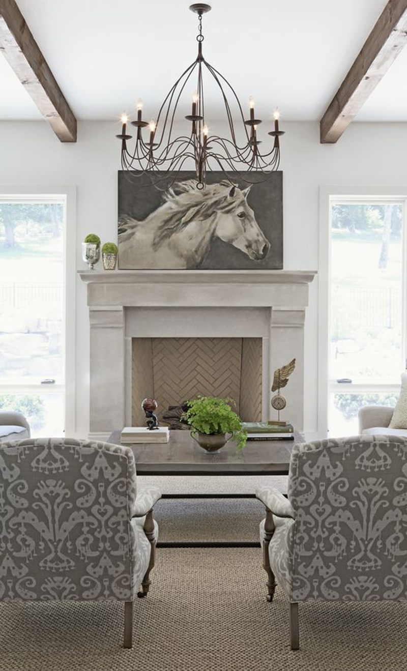 Картина белой лошади над белым камином в гостиной.