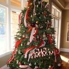 Веселая новогодняя елка украшенная лентами и разноцветными украшениями.