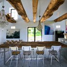 Обеденный стол со столешницей из повторно используемого дерева является продолжением длинной кухонной поверхности.