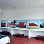 Спальня с картинами выстроенными на полочке напротив кровати.