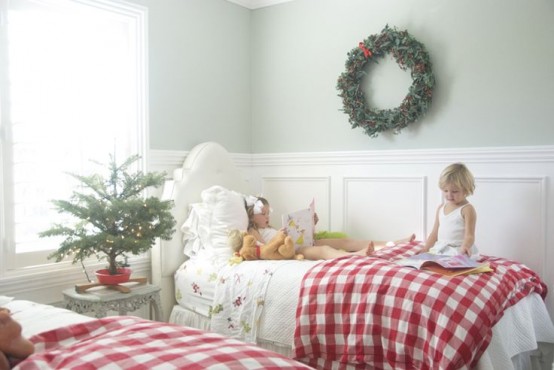 Маленькая ёлочка на тумбочке, веночек на стене, клетчатые покрывала и комната излучает дух рождества.
