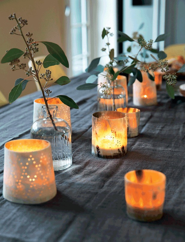 Праздничный стол украшен свечками в причудливых подсвечниках.