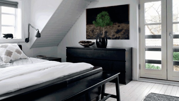 Спальня оформленная в черно-белых цветах украшена маленькой сосной в горшке.