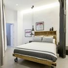 Спальня в стиле лофт с подвесными люстрами Тома Диксона и кроватью на колесах [Дизайн: Lupe Clemente Fotografia]