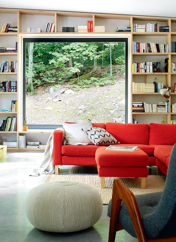 Когда дом находится в живописном лесу, есть смысл деать большие видовые окна. Книжные полки во всю стену не занимают места в комнате