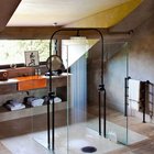 Минималистичная душевая кабина из стекла без рамы не отвлекает внимания от уникального дизайна душа в этой ванной комнате.