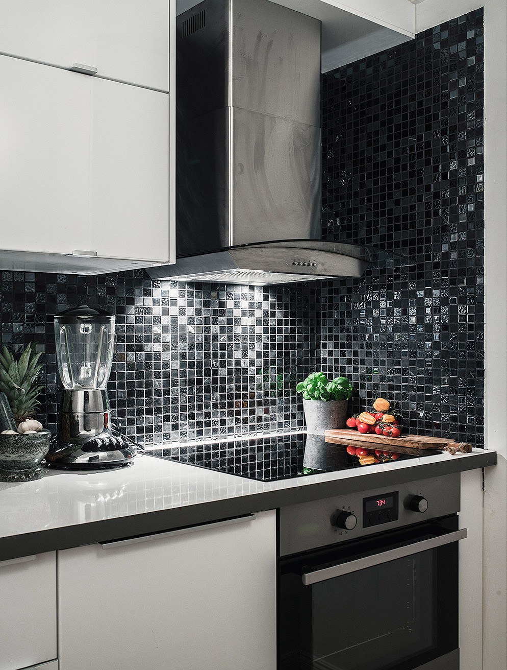 Кухня выдержана в черно-белых тонах с вкраплениями металла бытовых приборов