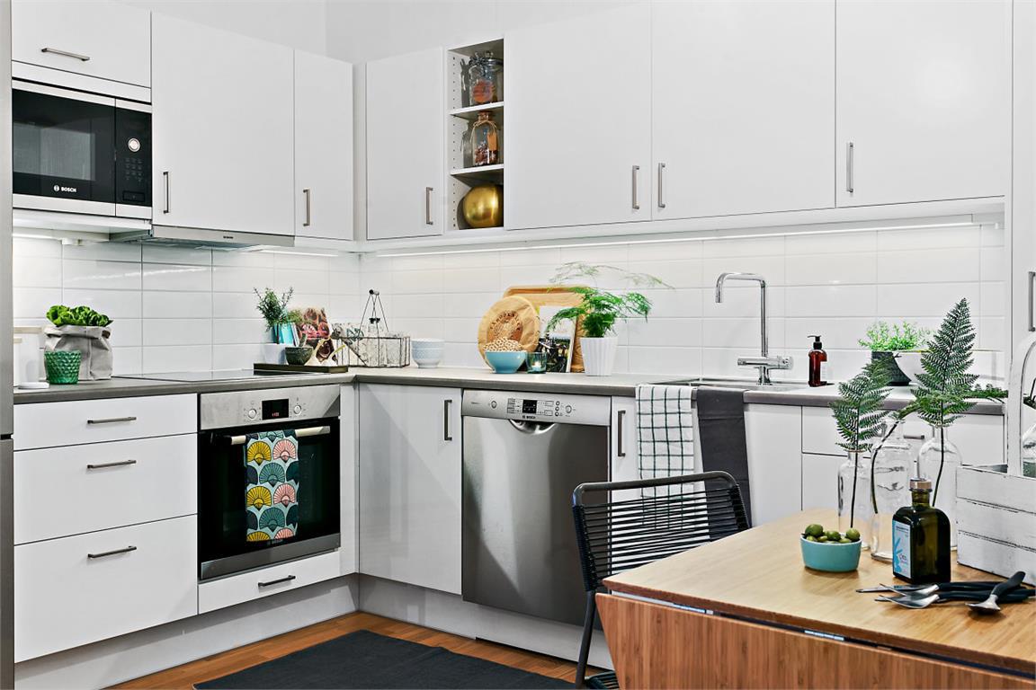 Благодаря белому фасаду кухня не создает ощущения что вы живете на кухне.