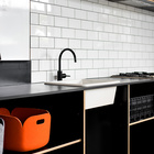 Простая черная кухонная мебель и не менее простая кафельная плитка.