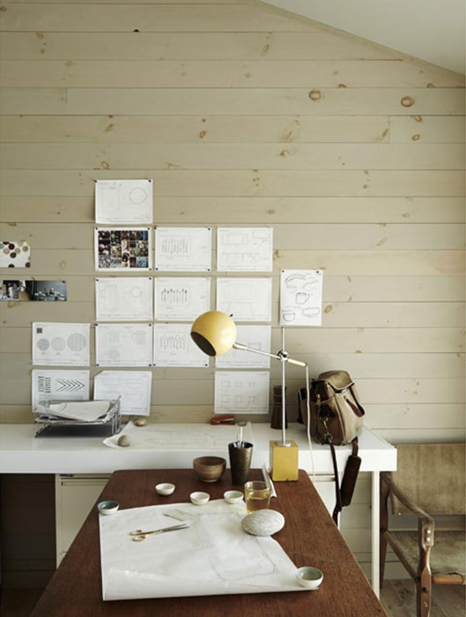 Домашний офис пары дизайнеров. Эскизы можно вешать прямо на деревянную стену. Внимание привлекает желтая настольная лампа в стиле середины 20-го века