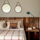 Декор второй спальни еще проще - рустикальное изголовье кровати и два круглых зеркала разного размера.