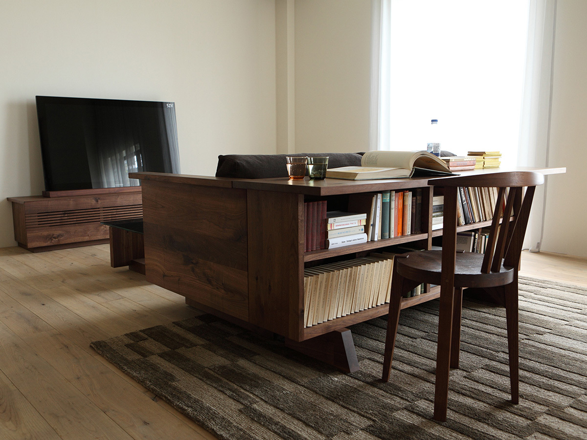 Книжный стеллаж-стол в интерьере установленный за диваном.