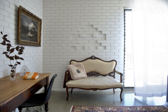 Интерьер домашнего офиса эклектичен, чего только стоит диванчик в стиле барокко на фоне белой кирпичной стены...