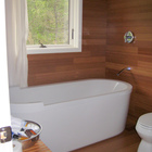 Одна из ванных комнат с ванной обшита деревом в соответствии с общим интерьером дома.