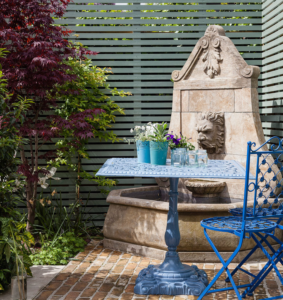 Кованый столик в саду у фонтана