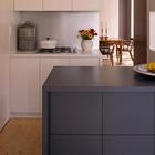 Кухонный остров контрастного серого цвета служит дополнительной поверхностью на кухне.