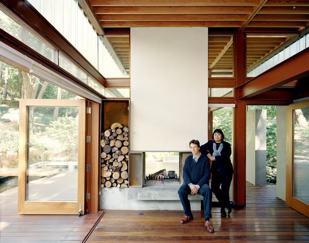 Brigitte Shim и Howard Sutcliffe - архитекторы проекта у камина в гостевом доме.