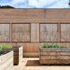 Фасад пристройки деревянный. Он отлично сочетается с окружающими дом виноградными лозами и выглядит уместно, натурально и экологично.