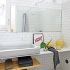 Дизайн ванной традиционно, для стиля лофт, сдержанный и простой с большим умывальником. При этом ванна очень светлая благодаря окну и белому кафелю на стенах.