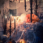 Скелеты, тыквы, свечи и паутина в очень интересной праздничной композиции.