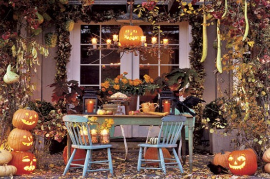 Отлично украшенный тыквами, свечками, листьями стол на террасе у дома.