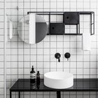Мебель в ванной главной спальне повторяет сетчатую структуру стеллажа в жилой комнате, только окрашена в контрастный черный цвет.