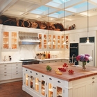 Элегантно использованные мансардные окна над кухонным островом в традиционной кухне.