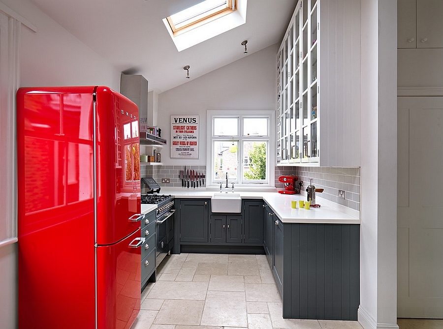 Великолепная кухня с серыми шкафами и красным акцентом в виде холодильника. Световое окно улучшает восприятие небольшого пространства