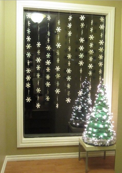 Маленькая елочка у у окна и гирлянды снежинок на окне. Скромно и празднично