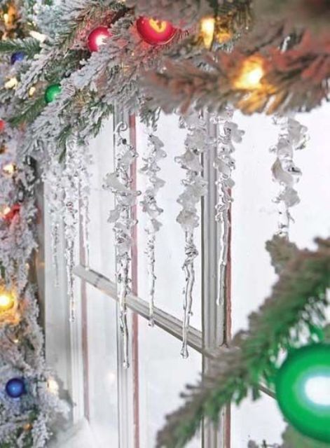 Окно можно украсить заснеженными еловыми веточками, светящейся гирляндой и игрушками в форме сосулек