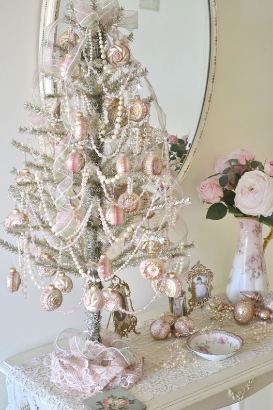 Уникальная настольная елка украшенная белыми бусинками и розовыми елочными игрушками.