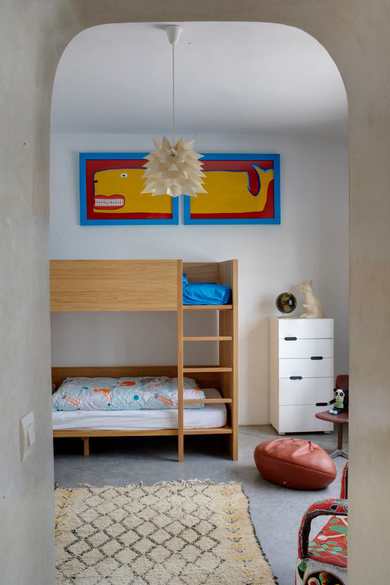 Детская комната с минимумом мебели. Центром комнаты является элегантная деревянная двухъярусная кровать.