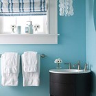 Голубой интерьер ванной комнаты с клетчатой римской шторой.
