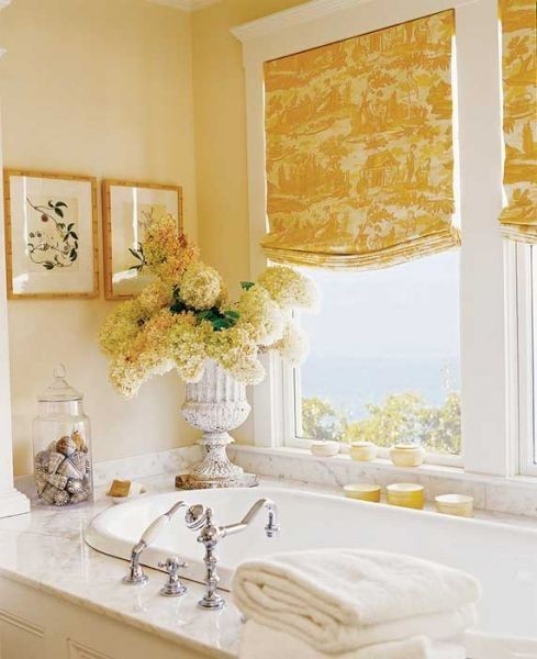 Желтые шторы с интересным принтом на окне с видом на море.