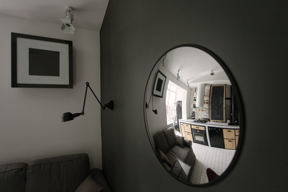 Выпуклое круглое зеркало служит украшением этой жилой гостиной