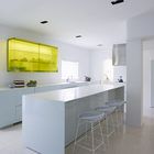 Смелая кухня с сильным акцентом в виде верхнего шкафа остекленного желтым стеклом. Фото: Ричард Пауэрс