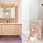 Ванна выполнена в розовых тонах, а мебель по стилю повторяет дизайн прикроватных тумбочек.