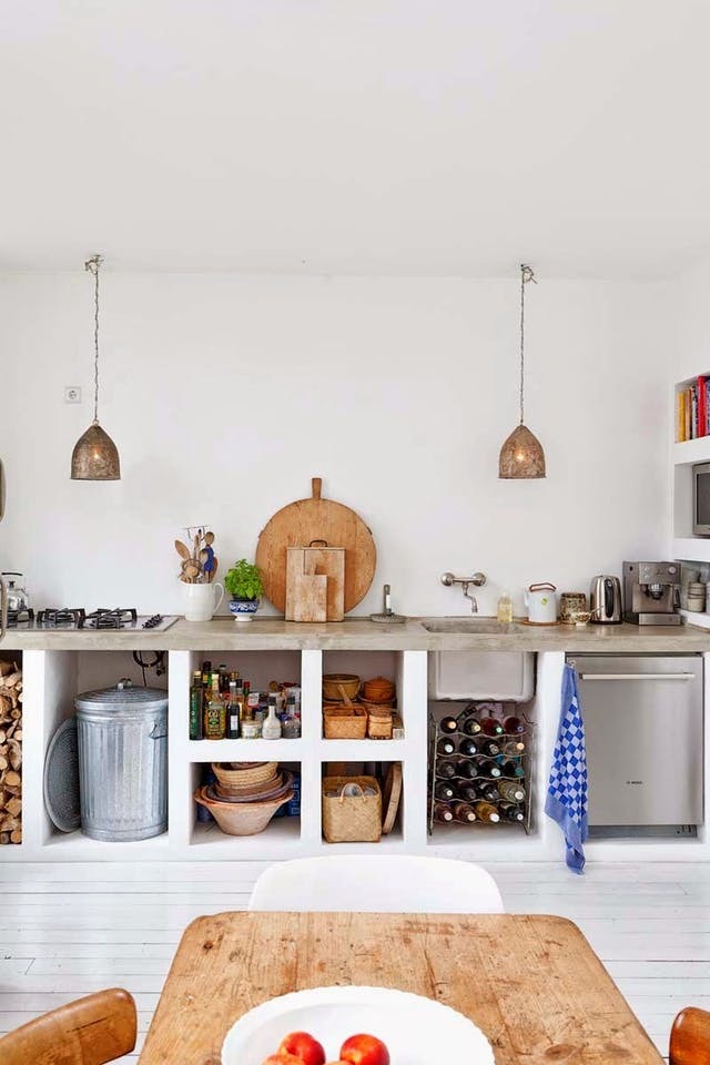 Бетонная кухонная столешница идеально вписывается в интерьер кухни в средиземноморском стиле. Сами полки под столешницей также выполнены из бетона, с той лишь разницей, что полки из белого бетона.