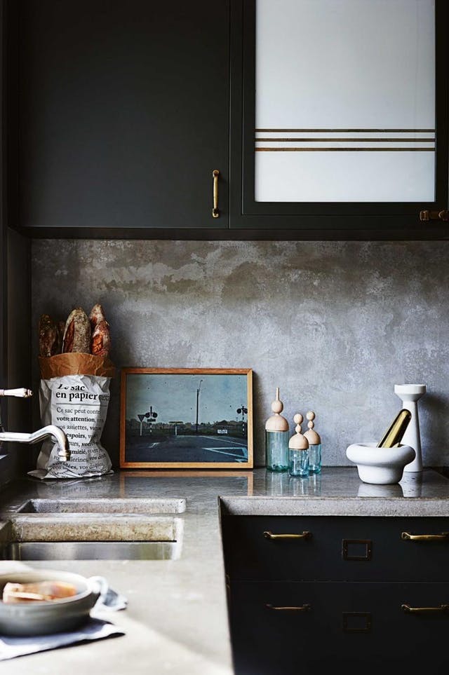 Кухонная столешница из бетона и бетонный кухонный фартук выглядят довольно холодно, однако эта холодность служит идеальным нейтральным фоном для аксессуаров и декора