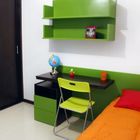 Современная детская с рабочим столом рядом с кроватью. Спальню оживляют зеленые и оранжевые акценты.