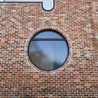 Большое круглое окно на фасаде выполнено из матового стекла дабы не нарушать приватности жильцов дома.