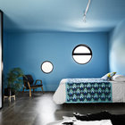Синий интерьер просторной спальни дарит умиротворяющее спокойствие.
